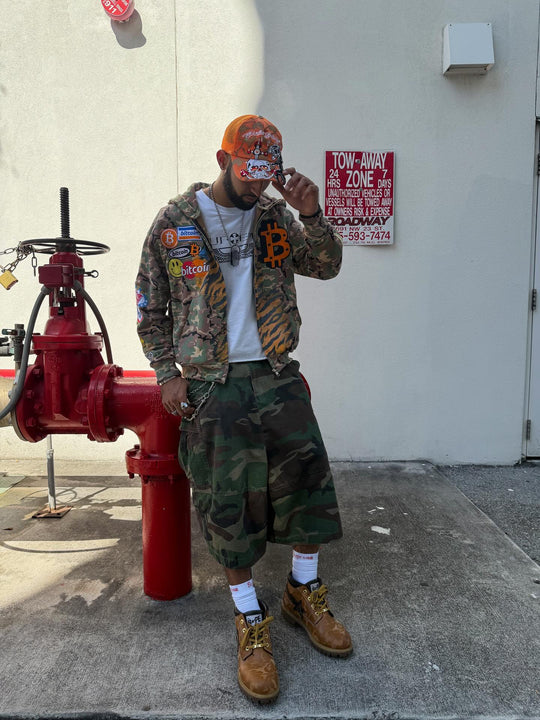 customer in the bitcoin camo k1 zip up and camo shorts beside a red fire hydrant